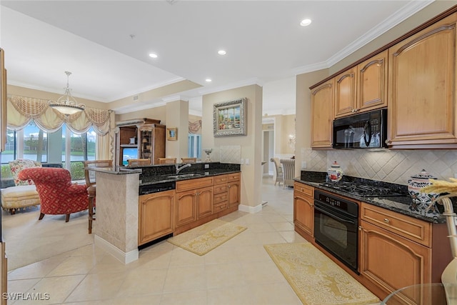 kitchen featuring decorative light fixtures, sink, dark stone counters, and black appliances