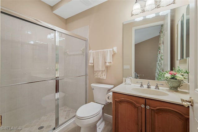 bathroom featuring vanity, toilet, and a shower with shower door