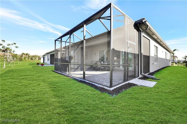 view of side of property with a lanai, a patio, and a lawn