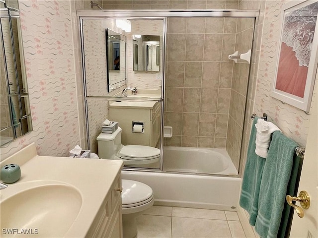 full bathroom with toilet, vanity, bath / shower combo with glass door, and tile patterned flooring