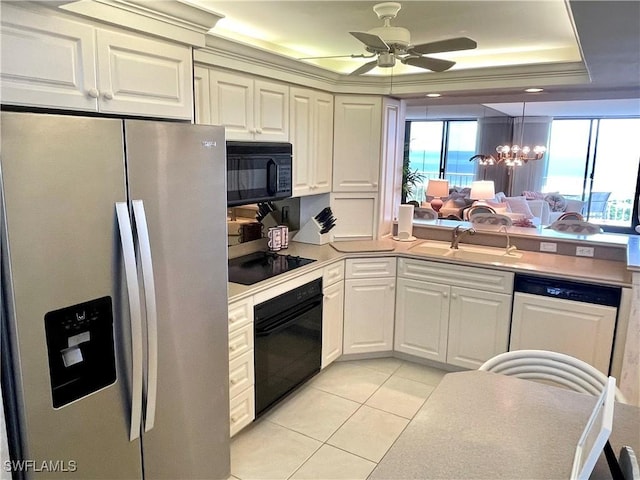 kitchen featuring sink, hanging light fixtures, light tile patterned floors, black appliances, and a raised ceiling