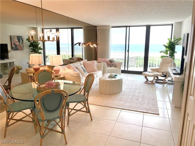 living room with a chandelier, a textured ceiling, light tile patterned floors, a wealth of natural light, and expansive windows