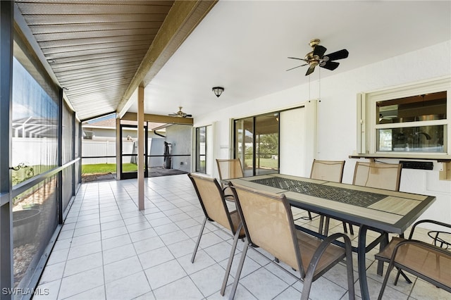 unfurnished sunroom with beam ceiling and ceiling fan