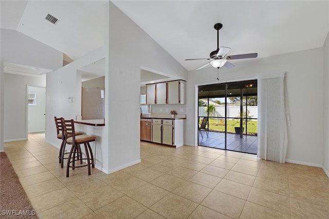 interior space featuring dishwasher, vaulted ceiling, light tile patterned flooring, and ceiling fan