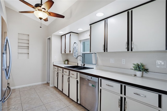 kitchen featuring appliances with stainless steel finishes, white cabinetry, sink, light tile patterned floors, and ceiling fan