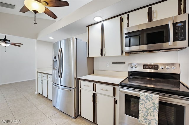 kitchen featuring stainless steel appliances, white cabinetry, light tile patterned flooring, and ceiling fan