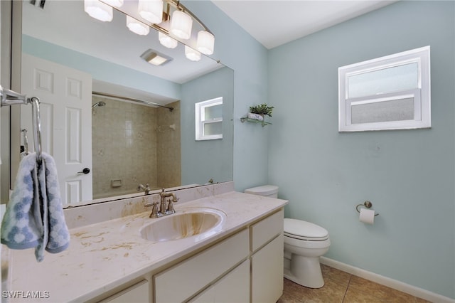 bathroom featuring vanity, toilet, tile patterned flooring, and a tile shower