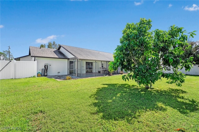 rear view of house with a lawn and a patio area