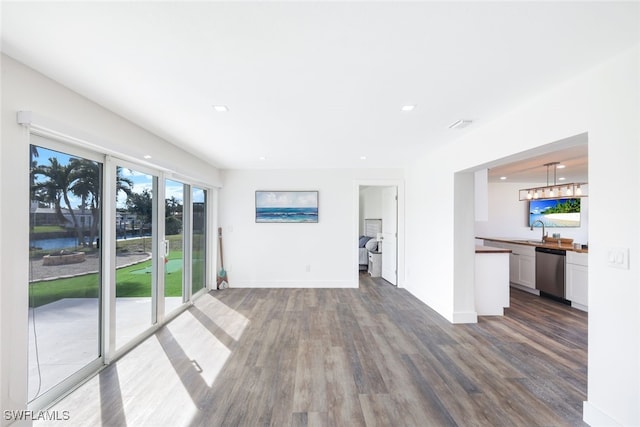 unfurnished living room featuring sink and hardwood / wood-style flooring