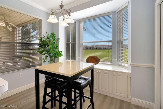 dining room featuring crown molding, light hardwood / wood-style floors, and ceiling fan