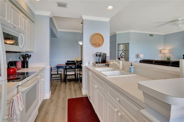 kitchen featuring sink, light hardwood / wood-style flooring, ornamental molding, white appliances, and white cabinets