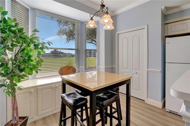 dining space featuring ornamental molding and light wood-type flooring