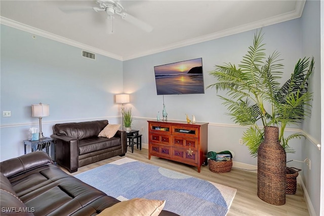 living room featuring ornamental molding, ceiling fan, and light hardwood / wood-style flooring