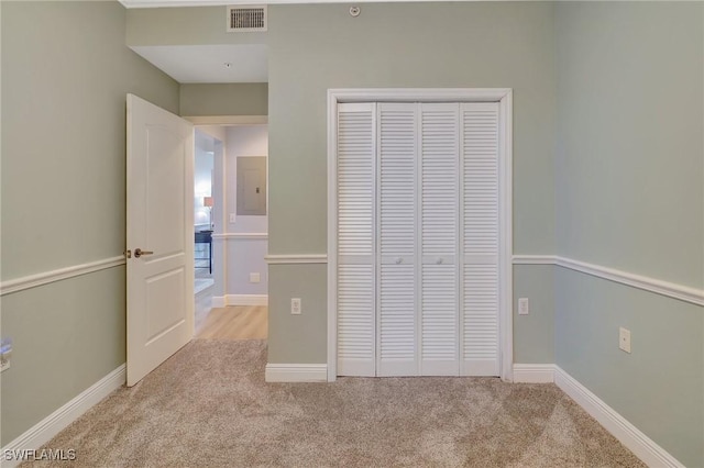 unfurnished bedroom featuring light colored carpet and a closet