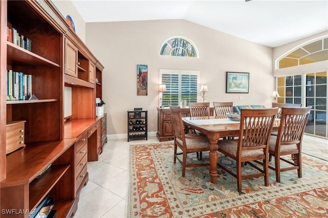 tiled dining space featuring vaulted ceiling