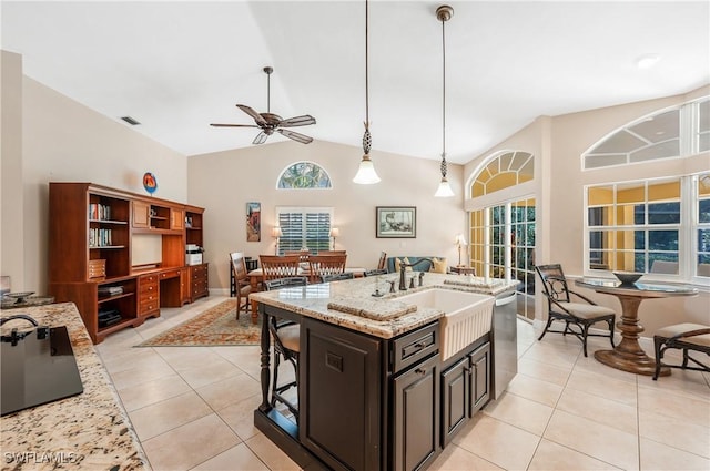 kitchen featuring light stone counters, decorative light fixtures, dishwasher, and light tile patterned flooring