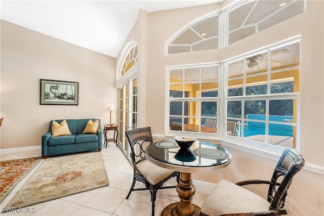 dining area with light tile patterned floors and high vaulted ceiling