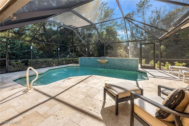 view of pool with a patio, a lanai, and pool water feature