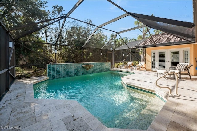 view of pool featuring french doors, a lanai, pool water feature, and a patio area