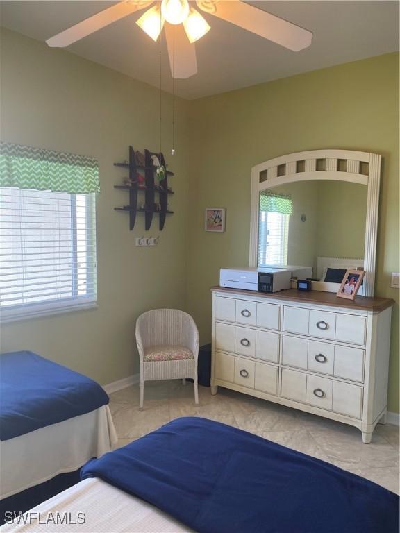 bedroom featuring ceiling fan and multiple windows