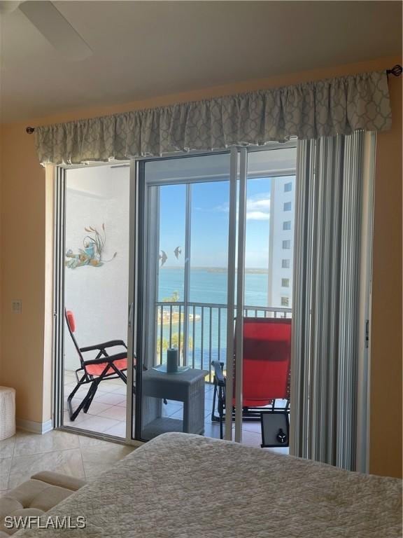 bedroom with light tile patterned floors, access to outside, and a water view