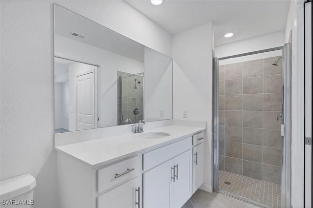 bathroom featuring vanity, tile patterned flooring, a shower with shower door, and toilet