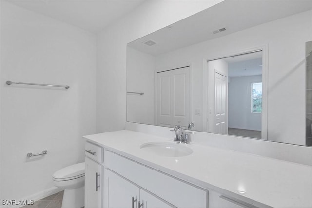 bathroom featuring tile patterned flooring, vanity, and toilet