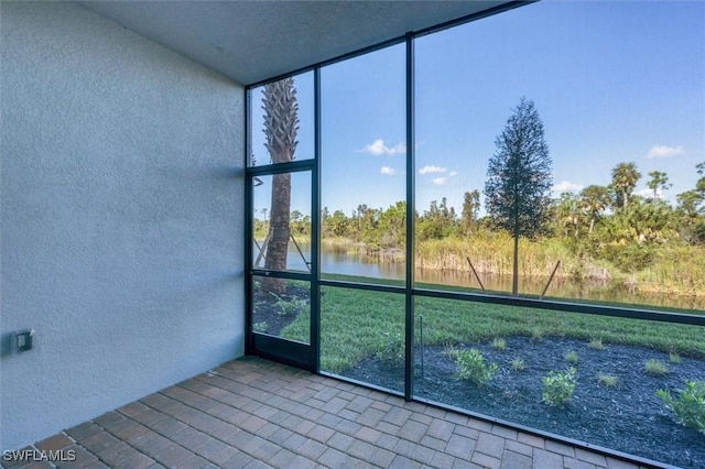 unfurnished sunroom with a water view