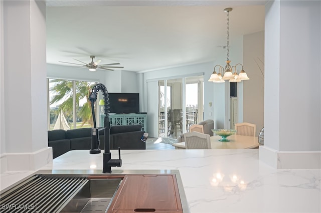 4198 Bay Beach Ln Unit 133, Fort Myers Beach, FL 33931 - kitchen featuring open floor plan, light stone countertops, healthy amount of natural light, and a chandelier