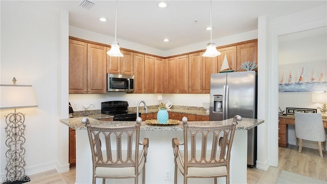9078 Albion Ln S Unit 6603, Naples, FL 34113 - kitchen featuring stainless steel appliances, light stone counters, a breakfast bar area, a center island with sink, and recessed lighting