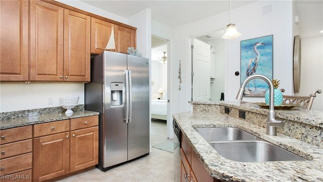9078 Albion Ln S Unit 6603, Naples, FL 34113 - kitchen with stainless steel appliances, a sink, brown cabinetry, and light stone countertops