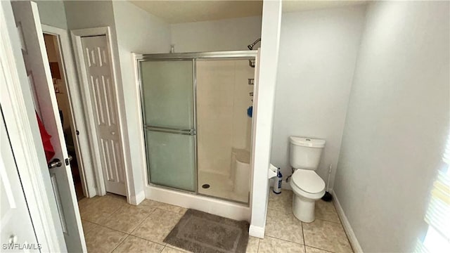 bathroom featuring toilet, tile patterned floors, and walk in shower