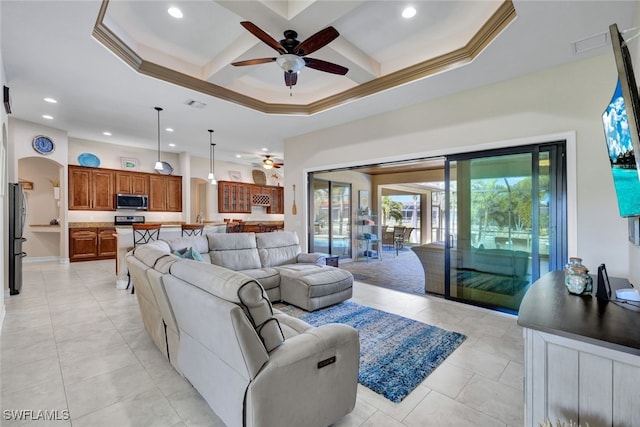 tiled living room featuring ceiling fan, a towering ceiling, coffered ceiling, ornamental molding, and beamed ceiling