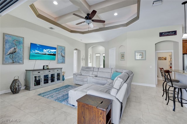 living room with ceiling fan, beam ceiling, a towering ceiling, coffered ceiling, and ornamental molding