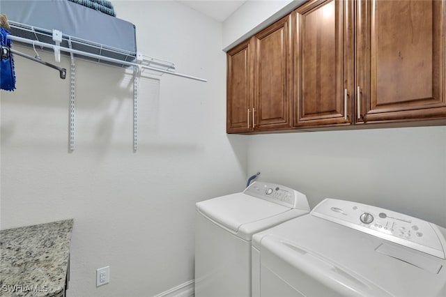 laundry area featuring washing machine and dryer and cabinets