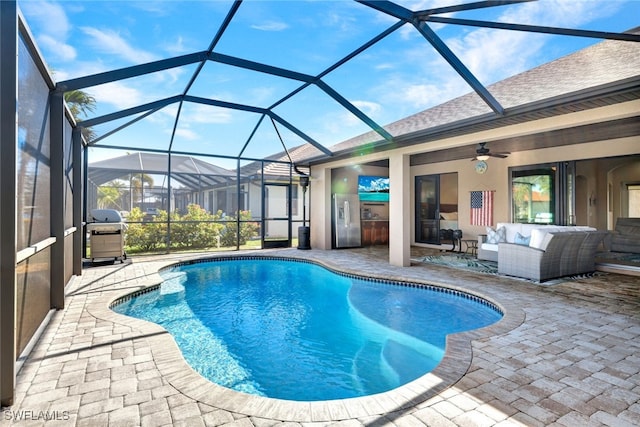 view of pool featuring ceiling fan, glass enclosure, an outdoor living space, grilling area, and a patio area