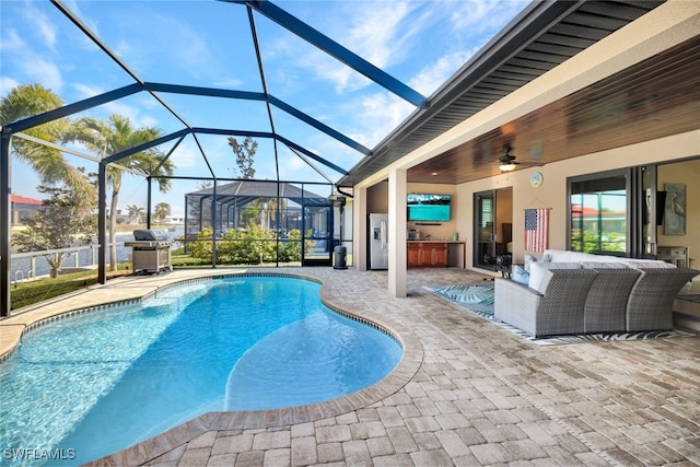 view of pool with area for grilling, glass enclosure, an outdoor living space, exterior kitchen, and a patio