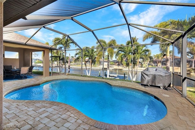 view of pool featuring a patio, a water view, area for grilling, and glass enclosure