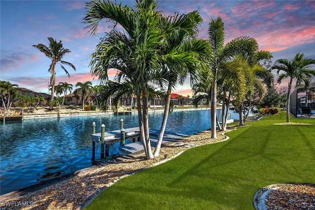 dock area featuring a lawn and a water view