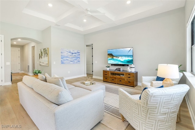 living room with light wood-style flooring, arched walkways, coffered ceiling, and recessed lighting