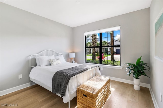 bedroom with baseboards and wood finished floors