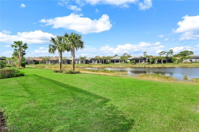 view of community with a residential view, a water view, and a yard