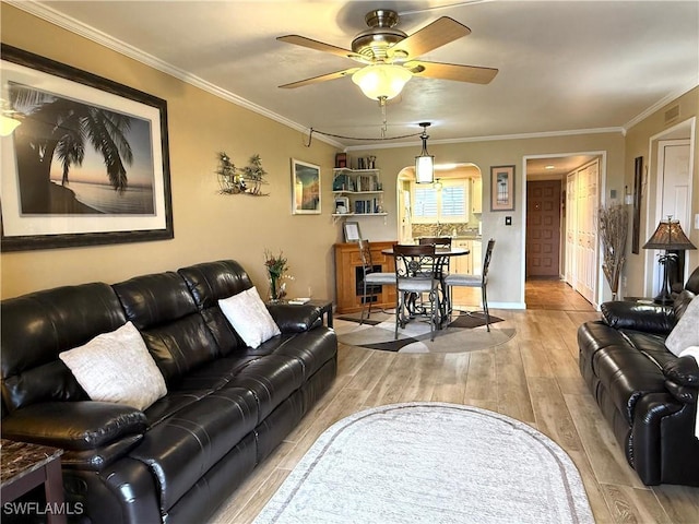 living room featuring crown molding, ceiling fan, and wood-type flooring