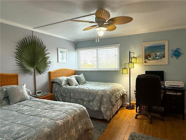 bedroom with crown molding, hardwood / wood-style floors, and ceiling fan