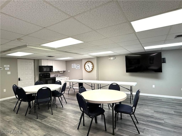 dining room with hardwood / wood-style flooring and a drop ceiling