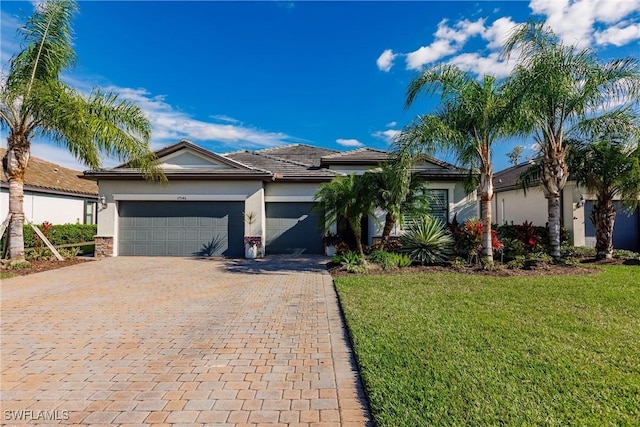 ranch-style home with a garage and a front lawn