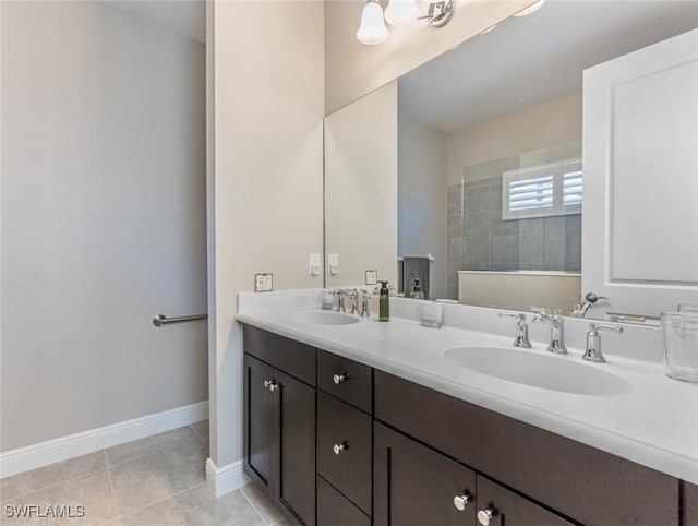 bathroom featuring tile patterned flooring, vanity, and tiled shower