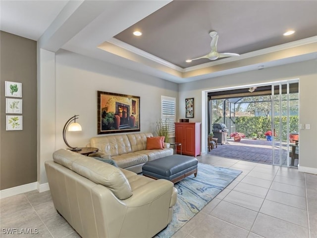 tiled living room featuring ornamental molding, ceiling fan, and a tray ceiling