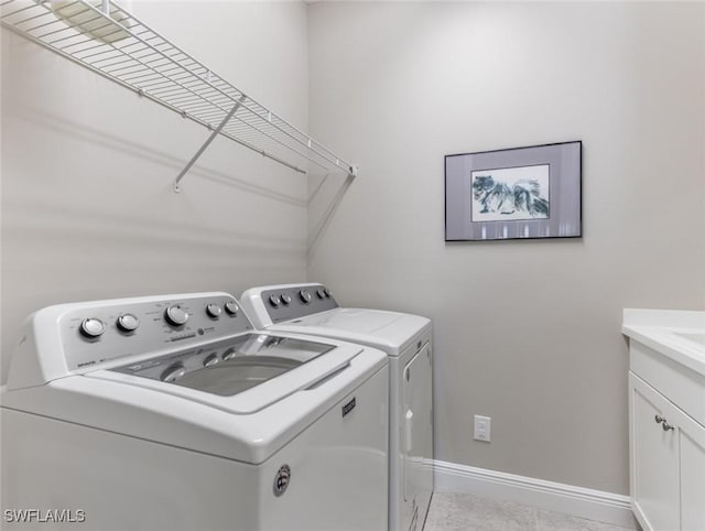 laundry room featuring cabinets and washer and clothes dryer