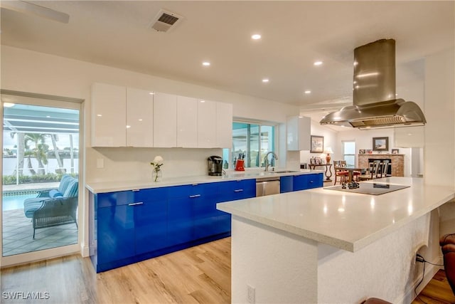 kitchen featuring black electric cooktop, island range hood, white cabinets, and light countertops